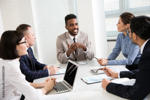 Group of multi-ethnic business people sitting around the office desk and discussing the project