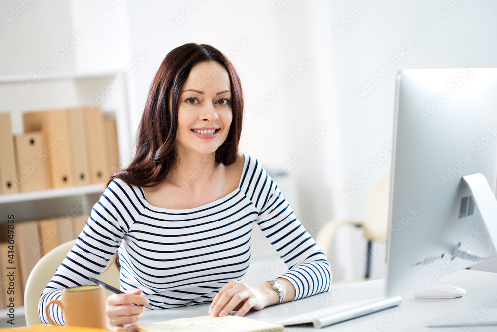 Portrait of business woman looking at camera at workplace in an office Portrait of business woman looking at camera at workplace in an office