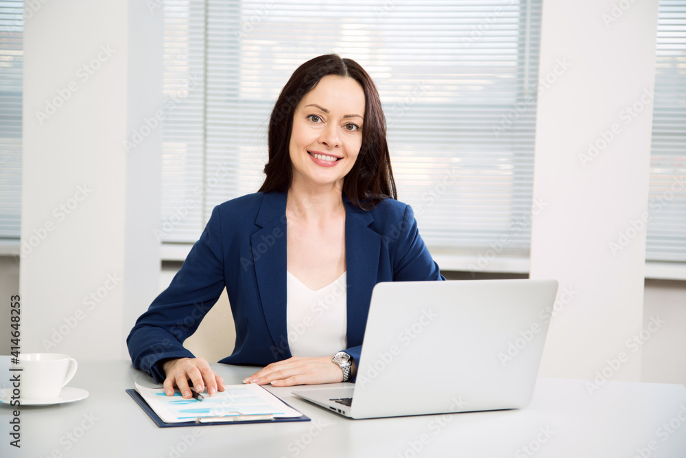 Portrait of business woman looking at camera at workplace in an office Portrait of business woman looking at camera at workplace in an office