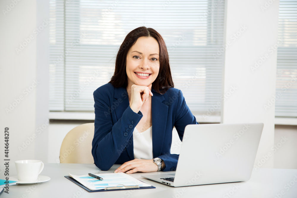Portrait of business woman looking at camera at workplace in an office Portrait of business woman looking at camera at workplace in an office