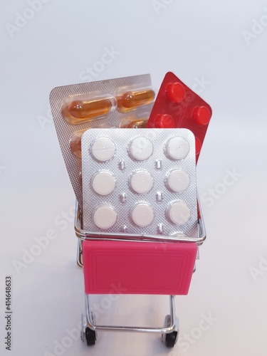 Food cart with pills on white background. Concept of medicine, treatment, use, purchase and sale of medicines.