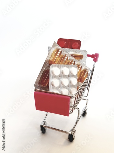 Food cart with pills on white background. Concept of medicine, treatment, use, purchase and sale of medicines.
