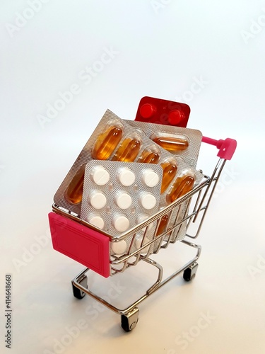 Food cart with pills on white background. Concept of medicine, treatment, use, purchase and sale of medicines.