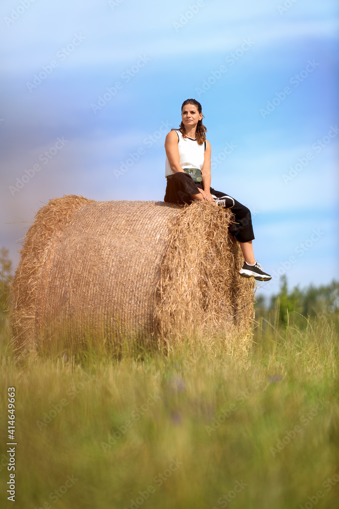 Young woman at the country side on a haystack Young woman at the country side on a haystack