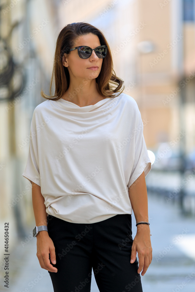 Young beautiful woman dressed in fashion clothing posing on the street Young beautiful woman dressed in fashion clothing posing on the street