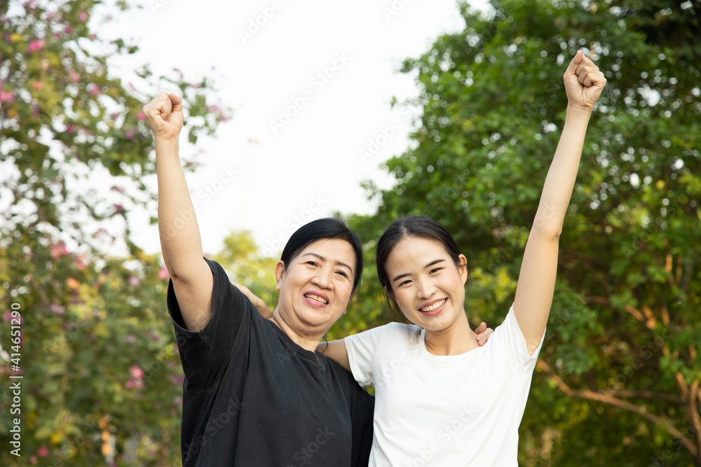 Healthy and strong senior mother staying in the park with asian young adult daughter, concept of family lifestyle, spring and summer wellness, family togetherness, mother and daughter, mother day Healthy and strong senior mother staying in the park with asian young adult daughter, concept of family lifestyle, spring and summer wellness, family togetherness, mother and daughter, mother day