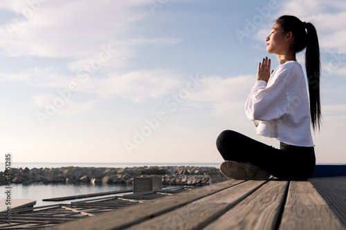 Fotografie young asian woman sitting meditating by the sea