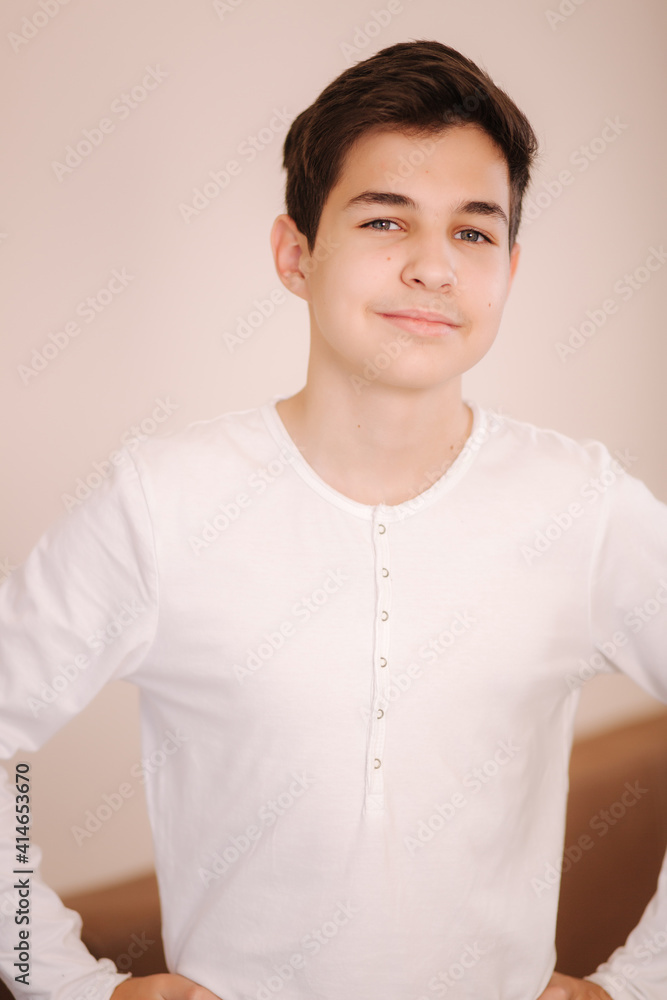 Portrait of young smiled teenage boy in white sweatshirt. Hppy handsome boy after playing games Portrait of young smiled teenage boy in white sweatshirt. Hppy handsome boy after playing games