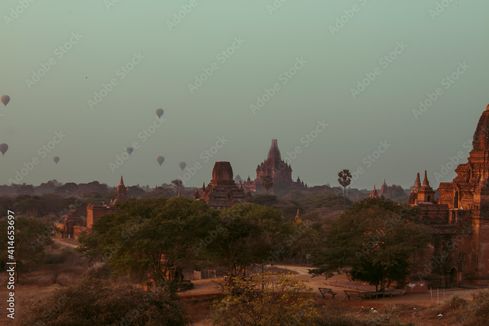 Obraz premium view of a scenic sunrise with many hot air balloons above Bagan in Myanmar. Bagan is an ancient city with thousands of historic buddhist temples.
