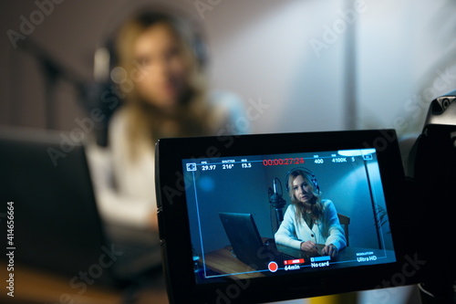 Girl video blogger. A cute girl is filming a video blog in her room. Focus on the camera screen. The background is blurred.