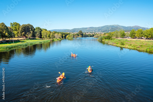 Group of people kayaking in the river Lima in a sunny day. Ponte de Lima, Portugal. photo