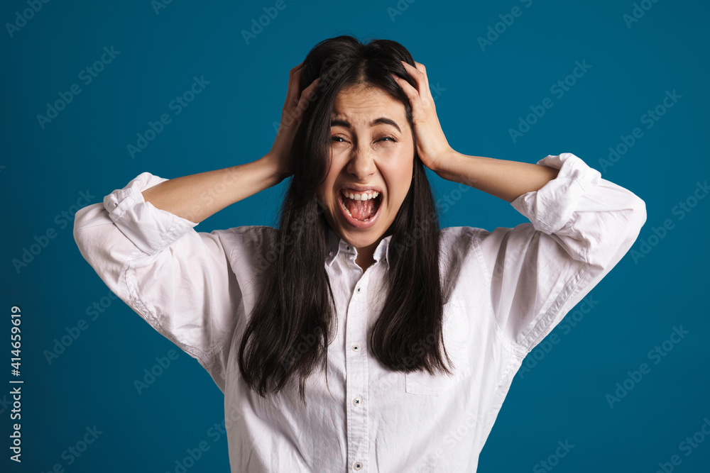 Unhappy beautiful asian girl grabbing her head and screaming Unhappy beautiful asian girl grabbing her head and screaming