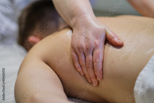 Close-up of man enjoying in relaxing back massage . Man relaxing on massage table receiving massage