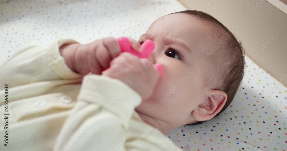 infant, childhood concept - close-up of smiling happy Baby plays with a teether. Teeth cutting. First teeth. Joy toothless 7 months baby bite, gnaws teether toy. slow motion infant, childhood concept - close-up of smiling happy Baby plays with a teether. Teeth cutting. First teeth. Joy toothless 7 months baby bite, gnaws teether toy. slow motion