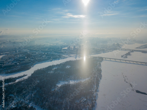 Light pillar from the sun over the Dnieper river in Kiev. Aerial drone view. Winter sunny morning.