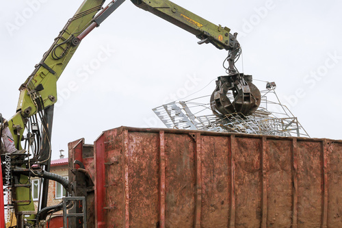 Εκτύπωση καμβά A grapple truck loads scrap industrial metal for recycling.