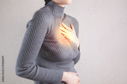 Young female suffering from severe chest pain photo