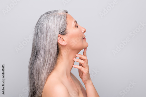 Profile portrait of optimistic nice long hair woman touch chin without clothes isolated on light grey color background photo