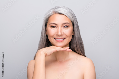 Portrait of attractive cheery gray-haired lady with smooth pure fresh skin isolated over grey pastel color background