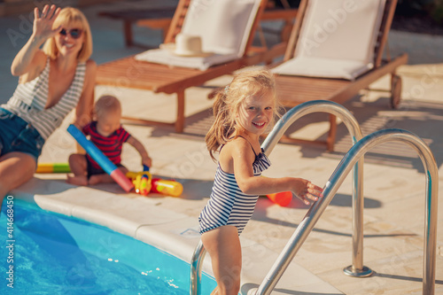 Mother playing with her kids by the swimming pool