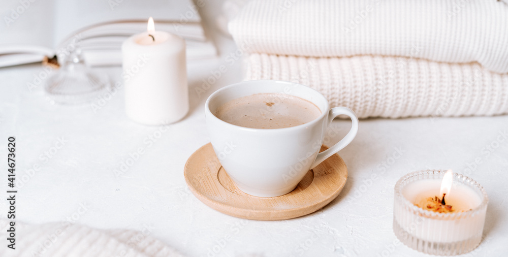 Details of still life in the home interior of living room. Cup of coffee, cotton, book, candle, sweater. Moody. Cosy autumn winter concept on white background. Decoration. Details of still life in the home interior of living room. Cup of coffee, cotton, book, candle, sweater. Moody. Cosy autumn winter concept on white background. Decoration.