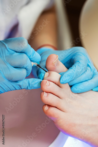 Process pedicure close up. Unrecognizable people. Master chiropody applying gel nail polish. Spa. Concept body care.