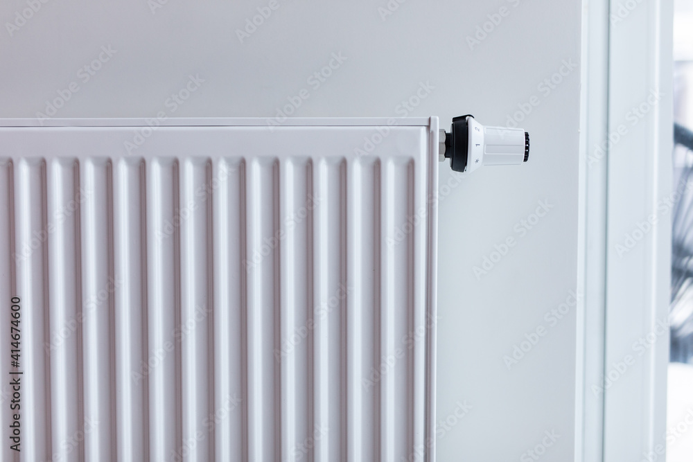 White radiator with temperature control valve. Central heating battery. White radiator with temperature control valve. Central heating battery.