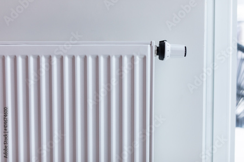 White radiator with temperature control valve. Central heating battery.