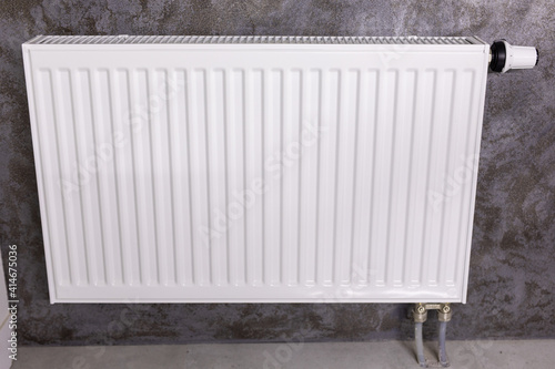 White radiator with temperature control valve. Central heating battery.
