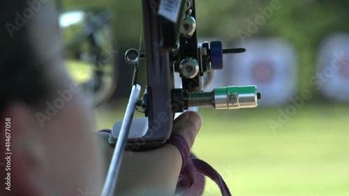 Aiming during olympic archery target practice, close up slow motion shot photo