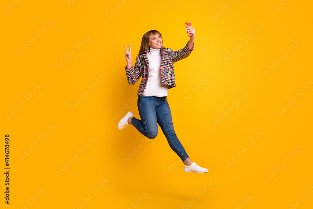 Full size portrait of carefree person make selfie fingers show v-sign wear plaid isolated on yellow color background Full size portrait of carefree person make selfie fingers show v-sign wear plaid isolated on yellow color background