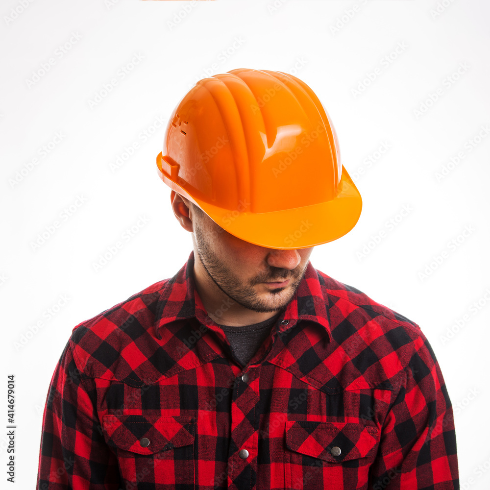 A man in a plaid shirt and a construction helmet on a white background. Concept Labor Day. A man in a plaid shirt and a construction helmet on a white background. Concept Labor Day.