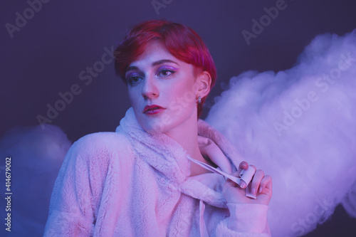 fashion portrait of a modern girl with an androgynous appearance in pink clouds photo
