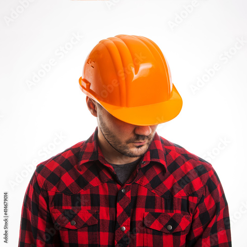 A man in a plaid shirt and a construction helmet on a white background. Concept Labor Day.