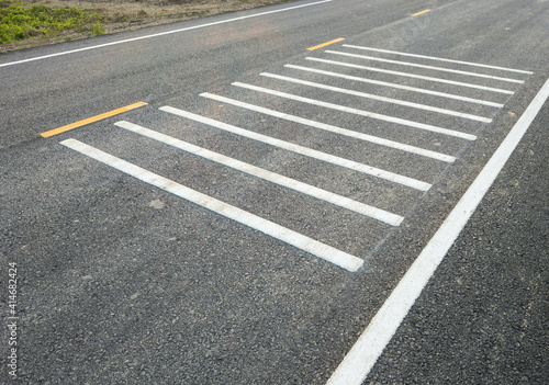 White transverse rumble strips on the asphalt road. photo