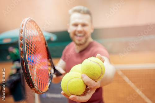 Smiling man trainer player prepares to serve tennis ball during match court © Parilov