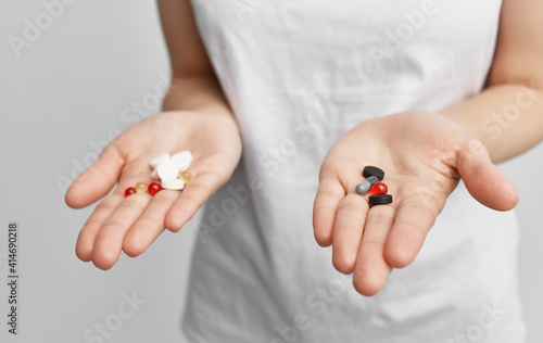 brunette in a white t-shirt with pills in her hands health problems