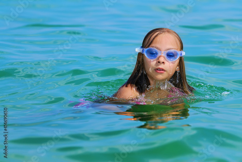 Smiling cute girl playing in the sea