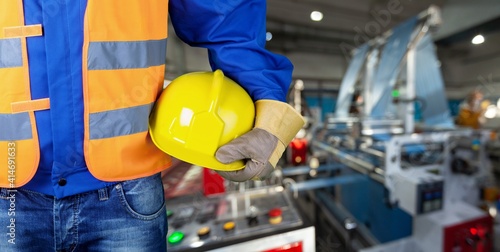 Worker man with helmet in hands on background photo