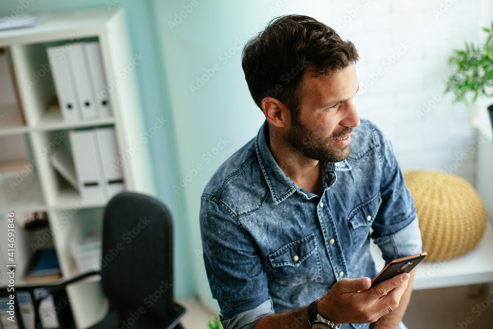 Businessman in office using the phone. Young man typing a message. Businessman in office using the phone. Young man typing a message.
