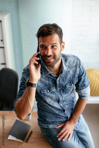 Businessman in office using the phone. Young businessman talking to the phone