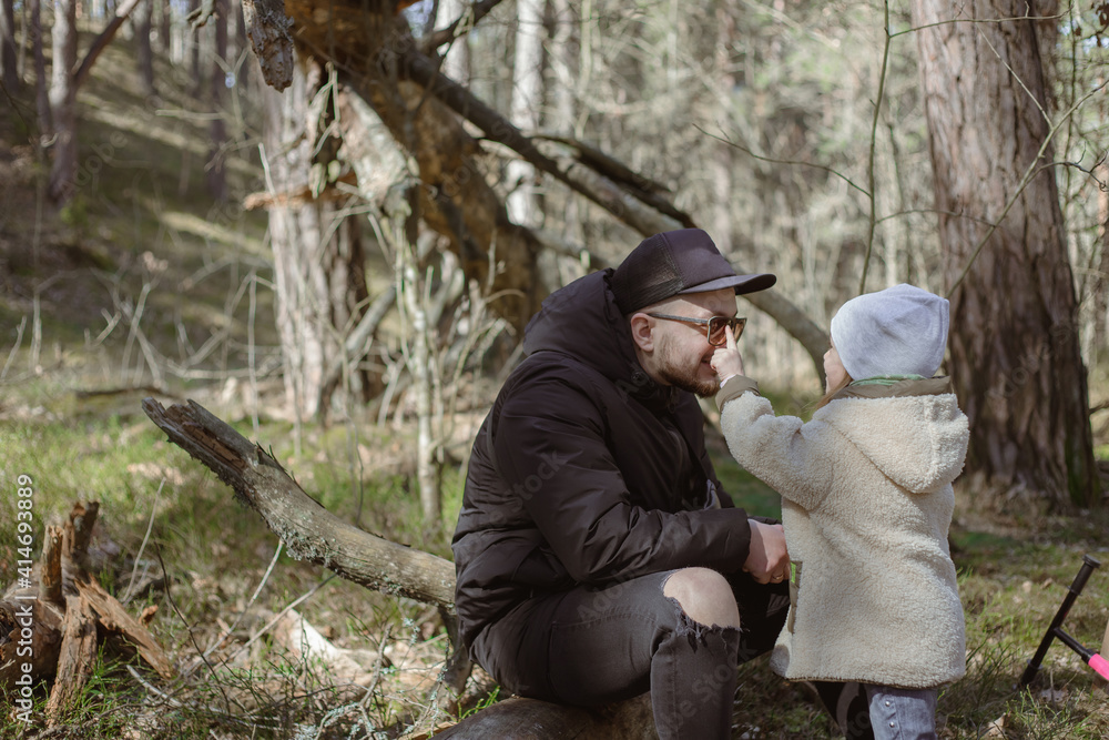 Father and little daughter spent time in he forest.Emotions, Lifestyle, Childhood concept.Family relationship. Little girl enjoying father's love outdoors. Happy family time.