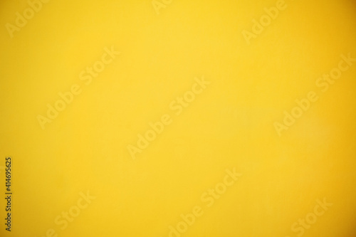 Yellow painted, empty wall background.