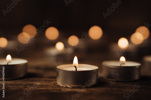 Close-up image of many burning candles in the dark. Bokeh effect background.