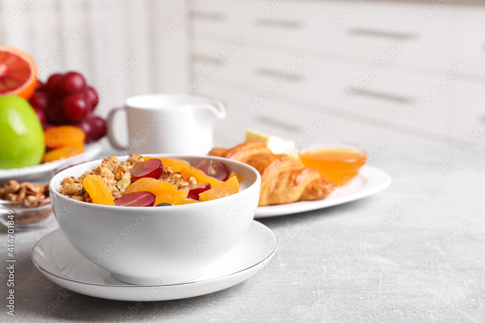 Delicious granola with fruits on white table. Space for text Delicious granola with fruits on white table. Space for text