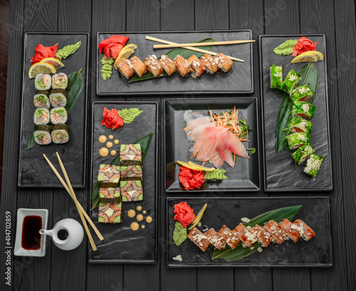 Fresh and delicious sushi set on black background