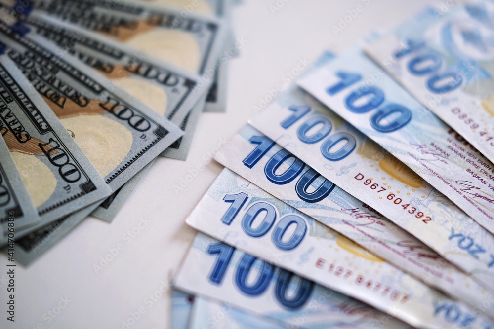 Side view of Turkish liras and dollars laid out in a pattern, close up of 100 banknotes of leading currency. Cash money texture. Banking concept. Side view of Turkish liras and dollars laid out in a pattern, close up of 100 banknotes of leading currency. Cash money texture. Banking concept.
