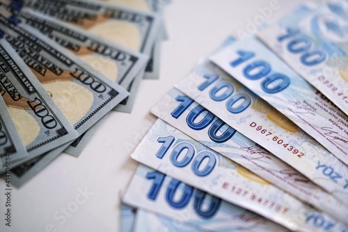 Side view of Turkish liras and dollars laid out in a pattern, close up of 100 banknotes of leading currency. Cash money texture. Banking concept. 