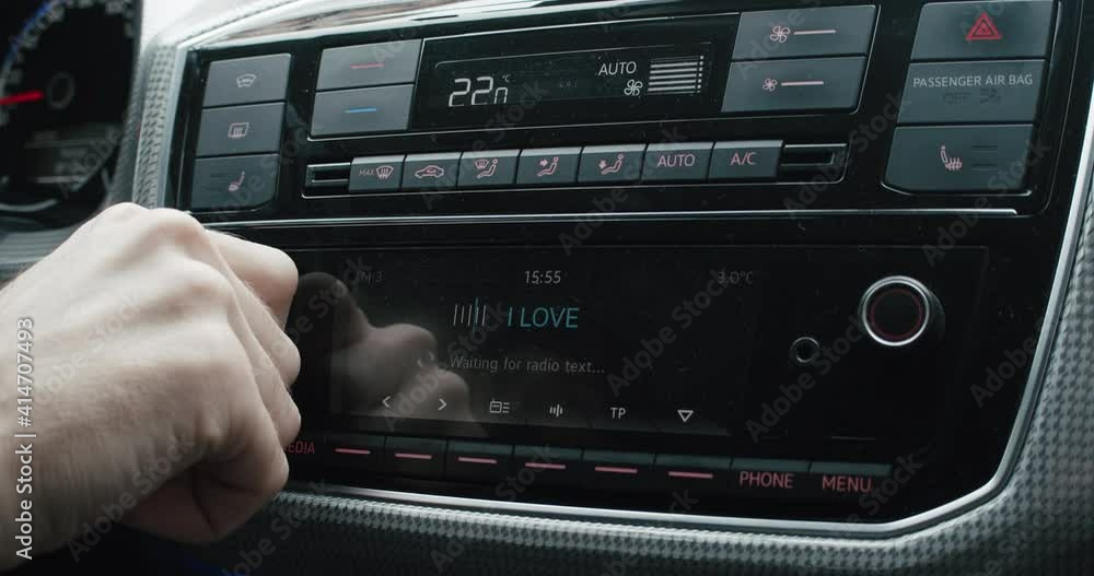 Driver changing car radio volume while driving Driver changing car radio volume while driving