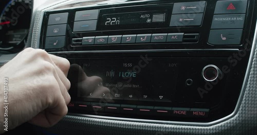 Driver changing car radio volume while driving